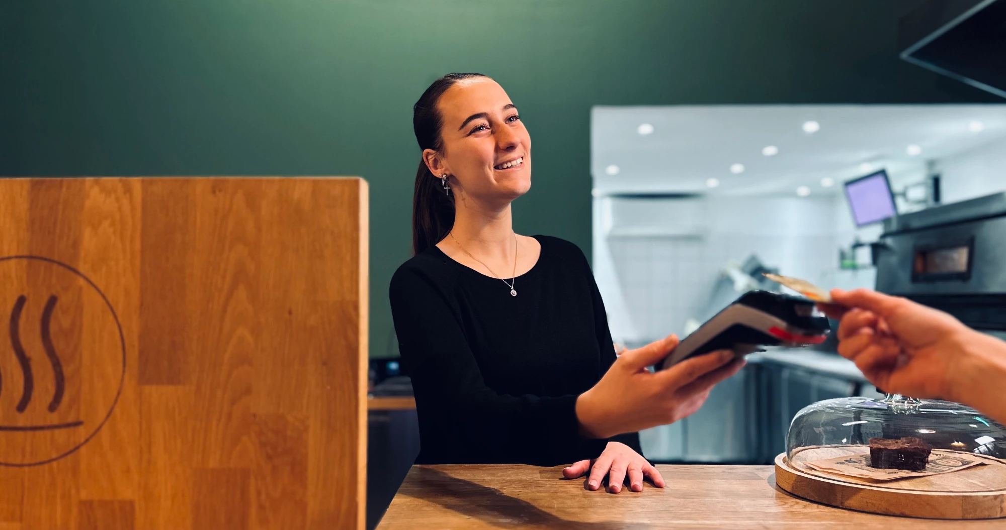 Hôtesse souriante de la pizzeria PIZZAPP tendant un terminal de paiement au client à Salon-de-Provence